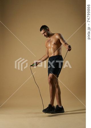 Seriously athlete with powerful torso doing element of sport exercises in the indoors 74799866