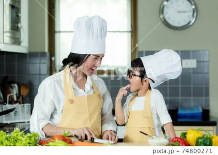 Cooking Family. Chef kid boy and mother making and leaning fresh vegetables salad for healthy eat 74800271