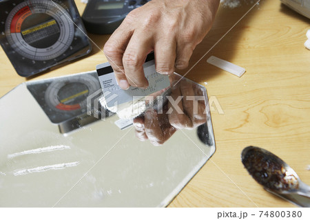 Man's Hand Preparing Cocaine Lines With Credit Card Man's Hand Preparing Cocaine Lines With Credit Card 74800380