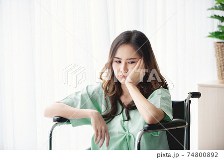 Sad and depressed asian woman in a wheelchair . Copy space on the window. Sad and depressed asian woman in a wheelchair . Copy space on the window. 74800892