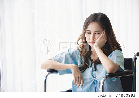 Sad and depressed asian woman in a wheelchair . Copy space on the window. Sad and depressed asian woman in a wheelchair . Copy space on the window. 74800893