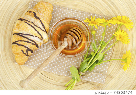 Fresh croissant, honey, yellow flowers. Fresh croissant, honey, yellow flowers. 74803474