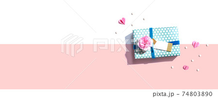 Gift box with a pink carnation flower 74803890