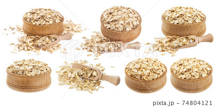 Isolated oat flakes. Wooden bowl and scoop with oatmeal 74804121