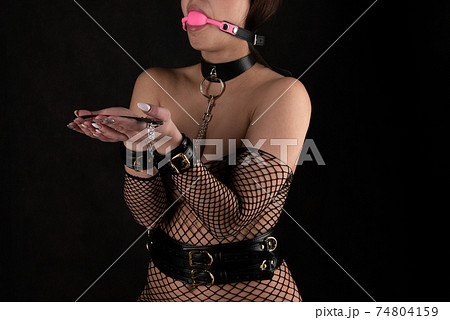 Beautiful woman in the role of a slave on a leash on black background 74804159