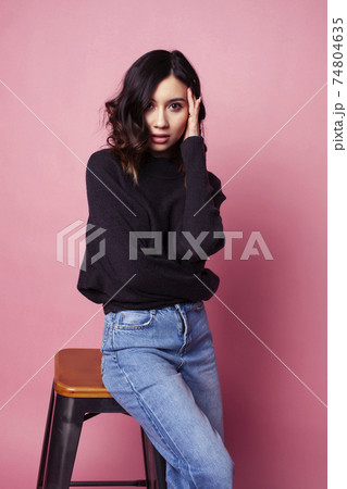 young pretty girl with curly hair posing cheerful on pink background, lifestyle people concept 74804635