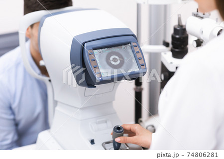Optometrist checking patients vision at the modern clinic 74806281