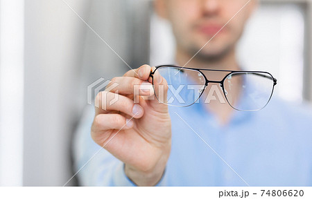 Closeup portrait of man showing spectacles to camera 74806620