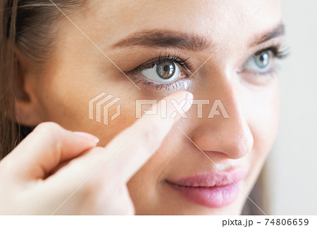 Young lady wearing contact eye lenses, close up Young lady wearing contact eye lenses, close up 74806659