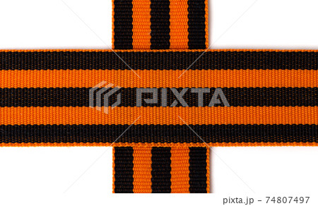 St. George ribbon on a white background. Black orange ribbon close up on a white background. 74807497