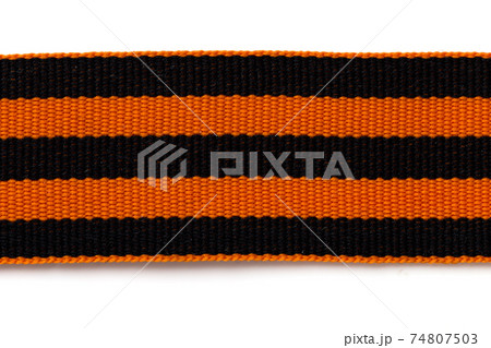 St. George ribbon on a white background. Black orange ribbon close up on a white background. 74807503