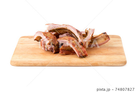 Smoked ribs on a white background. Smoked ribs on a wooden board isolated on white background. Smoked ribs on a white background. Smoked ribs on a wooden board isolated on white background. 74807827