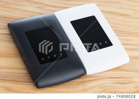 Two portable routers on the table. 4g routers on a wooden surface. 74808028