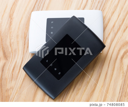 Two portable routers on the table. 4g routers on a wooden surface. 74808085