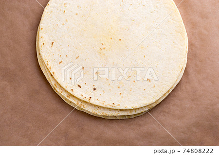 Tortilla on wrapping paper. Several mexican tortilla on the table. 74808222