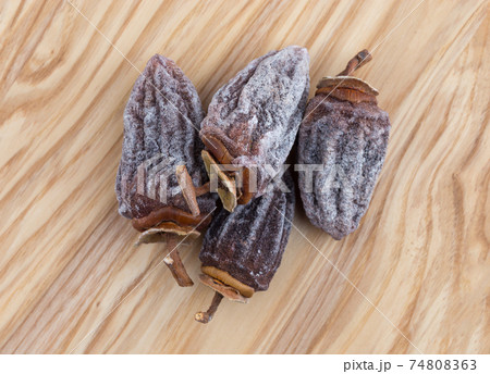 Dried persimmon on a white background. Fruits dried persimmon on a wooden surface. 74808363