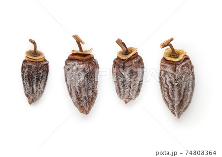 Dried persimmon on a white background. Fruits of dried persimmon close-up on a white background. 74808364