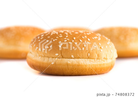 Burger buns on white background. A few buns cut in half close up on a white background. 74808372