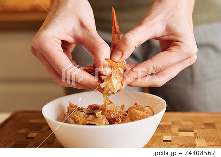 Woman cleaning shrimps for cooking. Process of hands peel shrimps shell 74808567