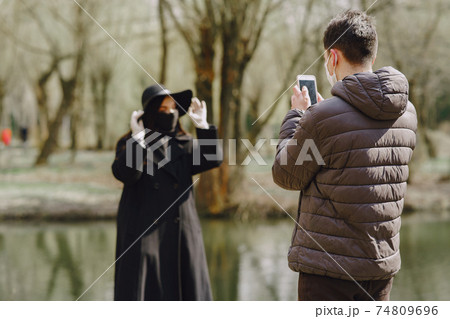 People in a masks stands on the street People in a masks stands on the street 74809696
