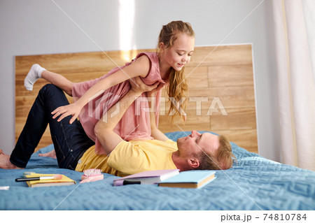 joyful loving young caucasian father spend funny time with excited little daughter joyful loving young caucasian father spend funny time with excited little daughter 74810784