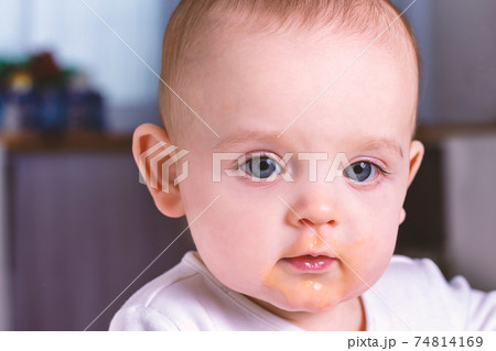 Caucasian baby with dirty face after eating. Caucasian baby with dirty face after eating. 74814169