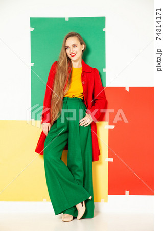 Happy fashionable woman in green pants in studio with white background 74814171