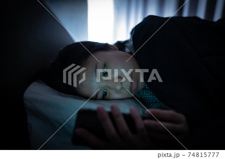 Asian woman on bed late at night and using mobile smartphone before sleep 74815777