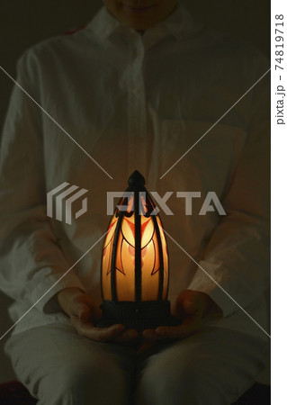 “アール・デコ” ランプ. 若い女性が灯す. フランス アンティーク（薄明かりの部屋・ソフト焦点） 74819718