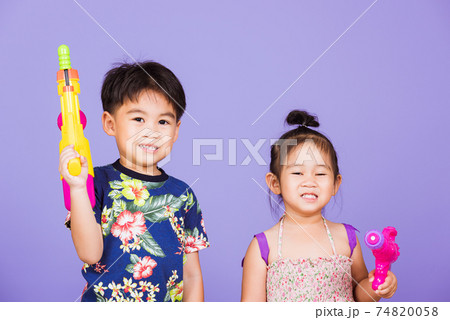 Two Happy Asian little boy and girl holding plastic water gun Two Happy Asian little boy and girl holding plastic water gun 74820058
