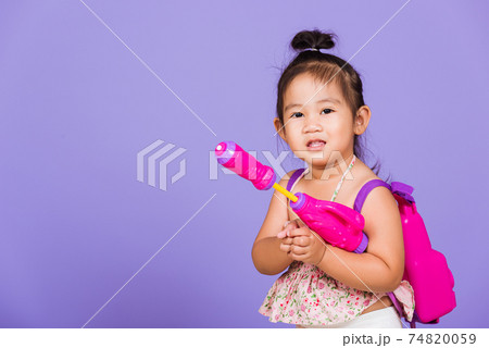 Thai child funny hold toy water pistol and smile 74820059