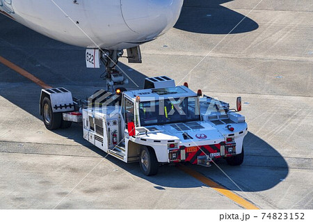 空港の風景　トーイングカーと飛行機　東京都大田区 74823152