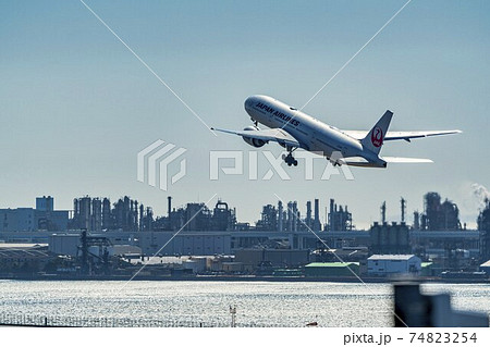 空港の風景 離陸中の飛行機と工場群 東京都大田区の写真素材