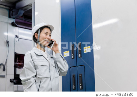 工場内でスマートフォンを使う女性 74823330