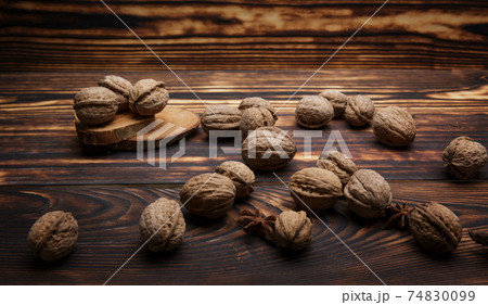 walnuts in shells lie on a dark wooden old table walnuts in shells lie on a dark wooden old table 74830099