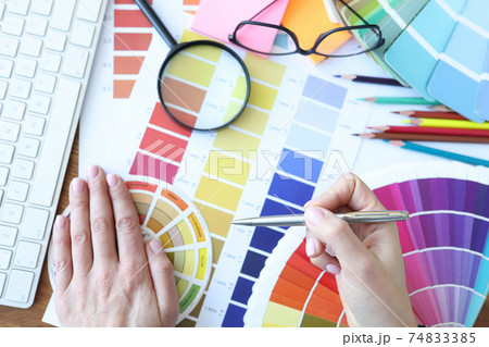 Designer develops color combinations on desktop closeup 74833385