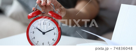 Woman lye on bed and turn off alarm clock close up. 74836048