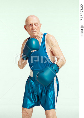 Senior man wearing sportwear boxing isolated on studio background. Concept of sport, activity, movement, wellbeing. Copyspace, ad. Senior man wearing sportwear boxing isolated on studio background. Concept of sport, activity, movement, wellbeing. Copyspace, ad. 74837802