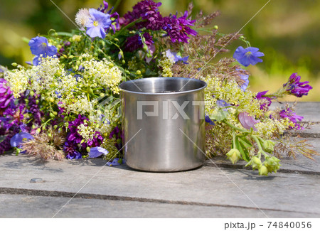 metal mug campaign is on the gray wooden table with a bunch 74840056