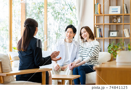 ビジネスウーマンの説明を聞く若い夫婦 ビジネスウーマンの説明を聞く若い夫婦 74841125