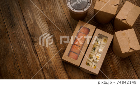 Asian food delivery. Packaging for sushi and woks. Food in paper containers Asian food delivery. Packaging for sushi and woks. Food in paper containers 74842149