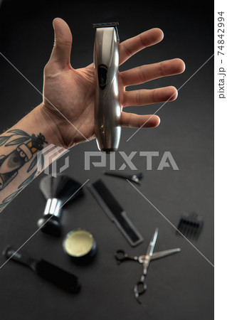 Hand of male barber with equipment set isolated on black table background. Hand of male barber with equipment set isolated on black table background. 74842994