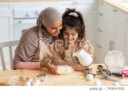 Young Muslim Mom Baking Together With Her Little Daughter In Kitchen Young Muslim Mom Baking Together With Her Little Daughter In Kitchen 74844381
