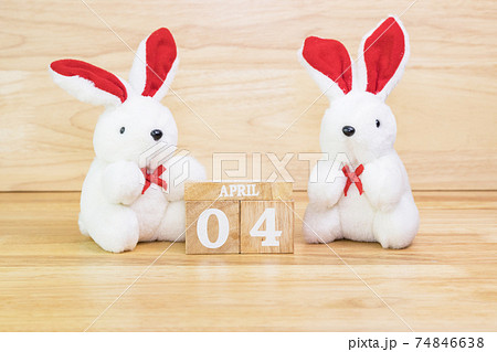 White rabbit doll with wood text April 4 on wood table 74846638
