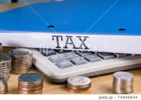 Folder Tax documents and stack of coin with calculator, concept Annual tax payment at work office 74846644