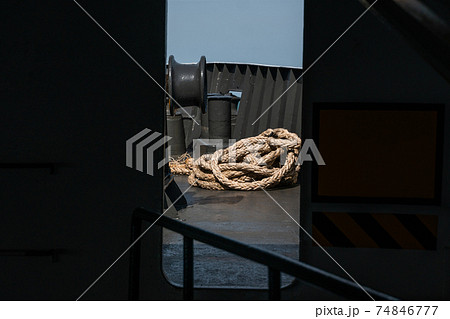 Rope on a sea boat for mooring a vessel is adhered to a pier. 74846777