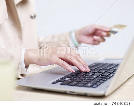hands of a young asian woman entering credit card numbers using laptop computer hands of a young asian woman entering credit card numbers using laptop computer 74846813