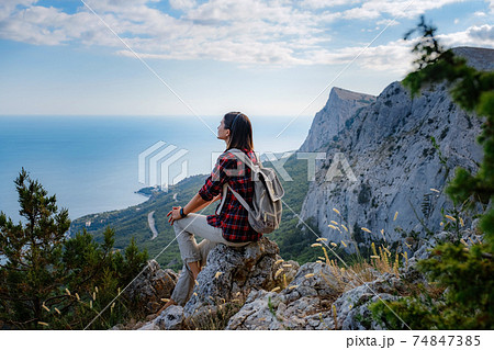 woman hiker enjoy the view at sunset mountain peak cliff woman hiker enjoy the view at sunset mountain peak cliff 74847385