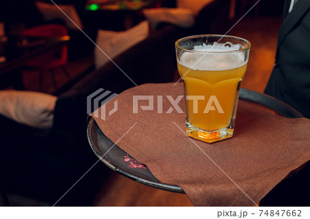 Waiter serving glasses of cold beer on the tray. Waiter serving glasses of cold beer on the tray. 74847662