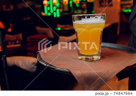 Waiter serving glasses of cold beer on the tray. Waiter serving glasses of cold beer on the tray. 74847664